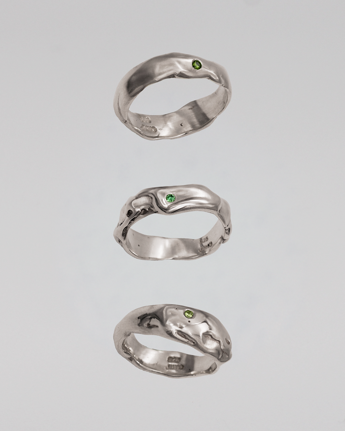 Three silver rings on a light gray background