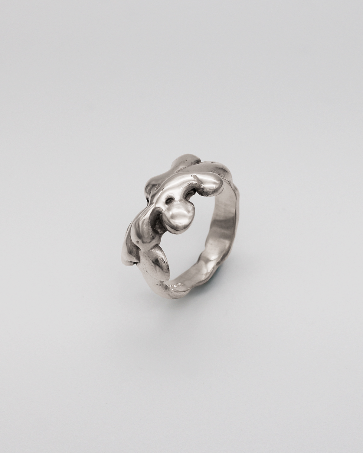 Silver ring with a unique design on a light gray background