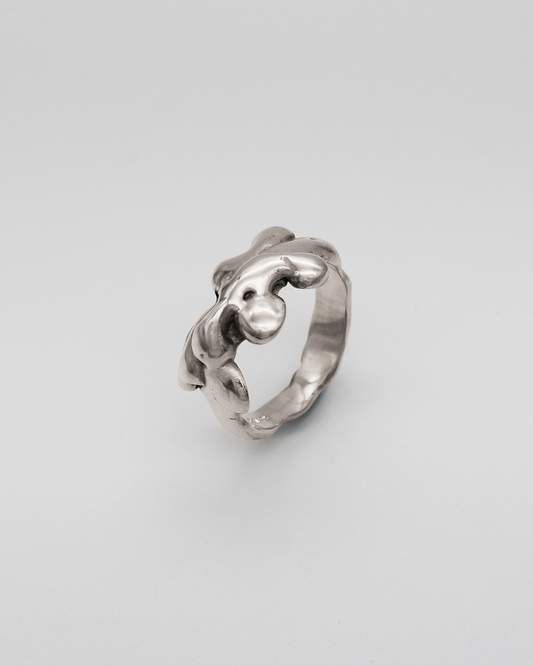 Silver ring with a unique design on a light gray background