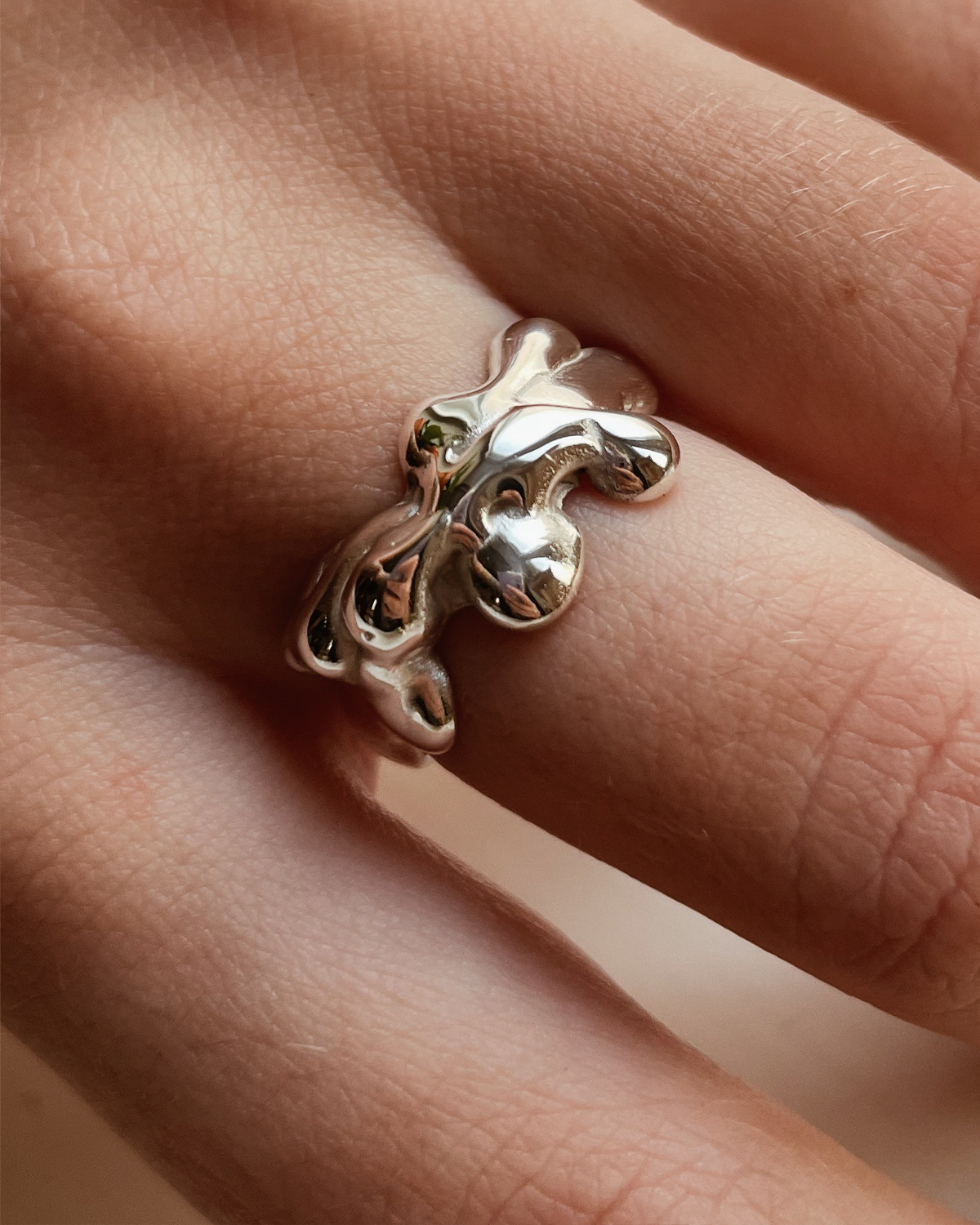 Silver ring with a unique design on a finger