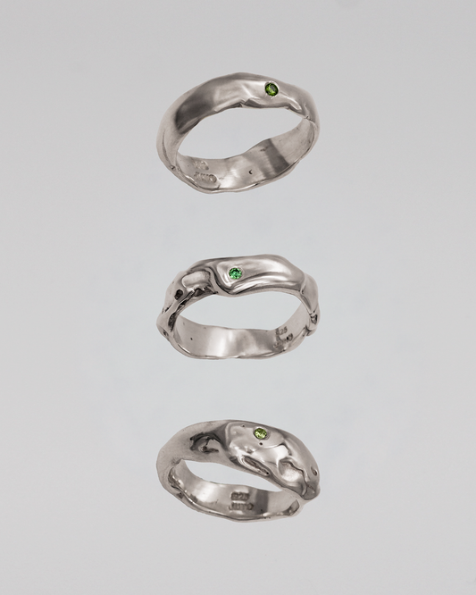 Three silver rings on a light gray background