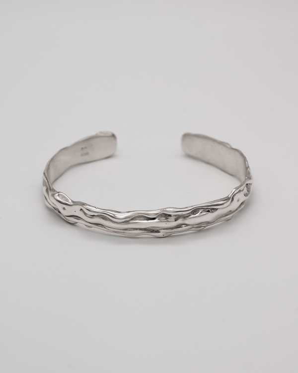 Silver bracelet on a light gray background