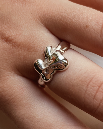 Silver ring on a finger with a blurred background