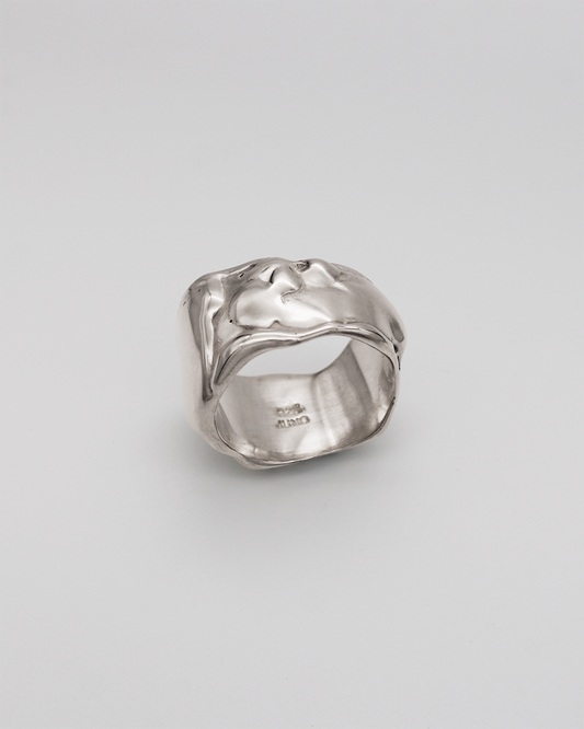 Silver ring on a light gray background