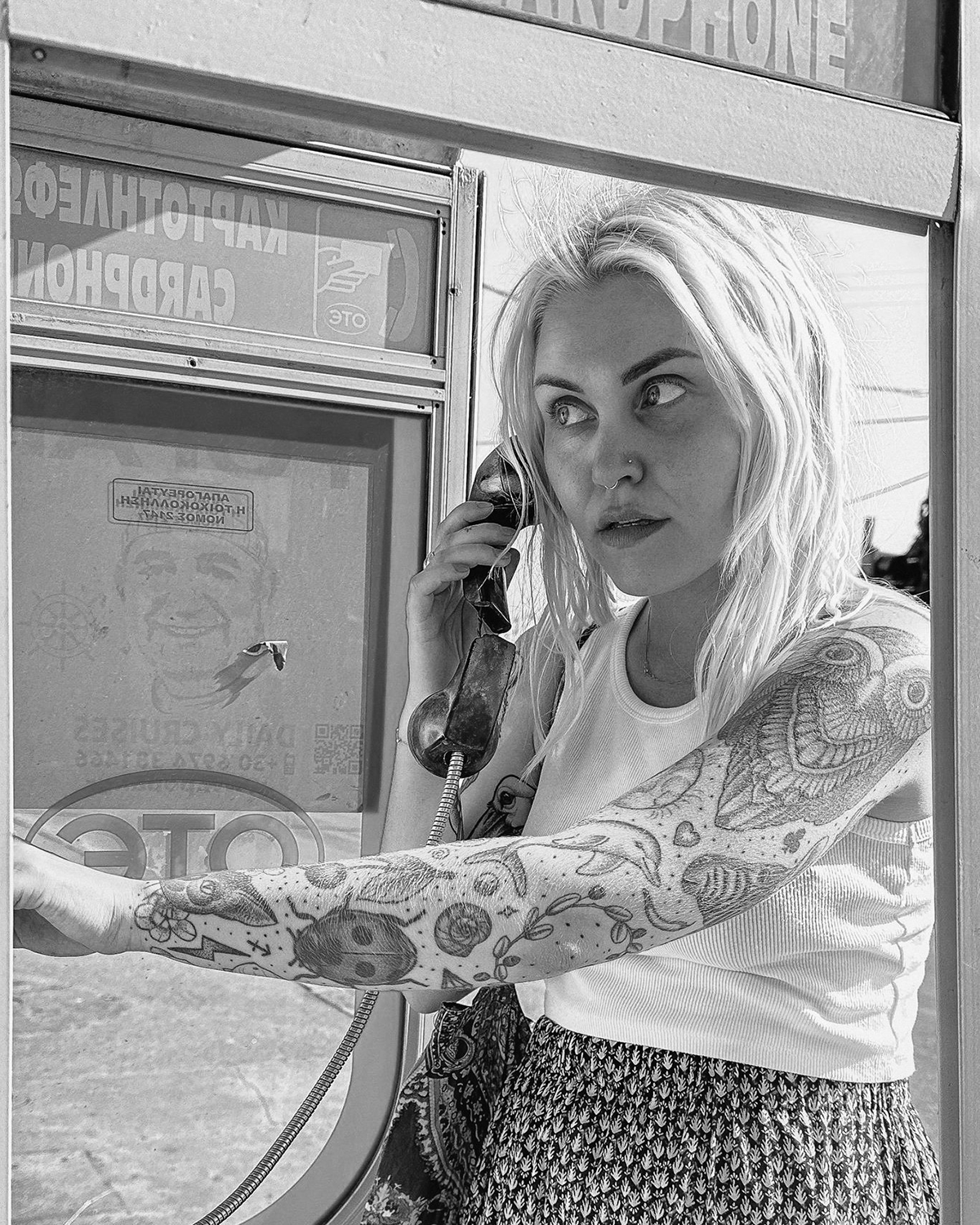 Woman using payphone in black and white photo