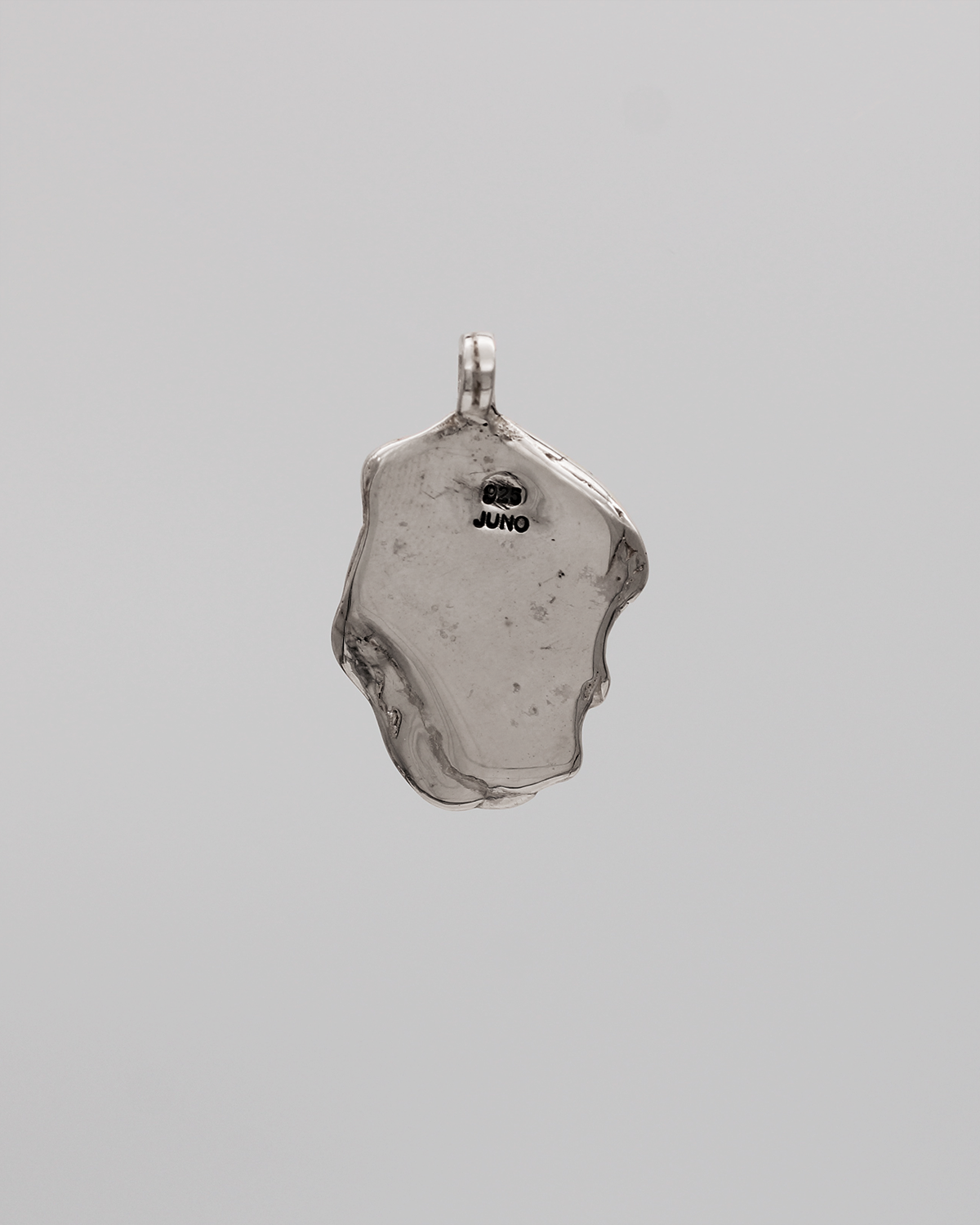 Silver pendant on a gray background