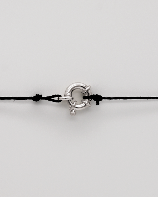 Black cord with a silver clasp on a light gray background